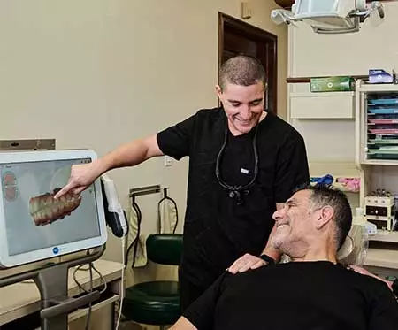 Dr. Gio of Flossy Smiles discussing a patient's dental x-rays with him