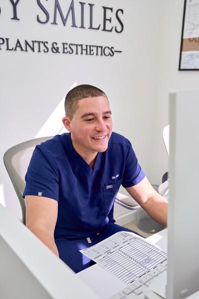 Dr. Gio helping a patient at Flossy Smiles Dental Implants & Esthetics