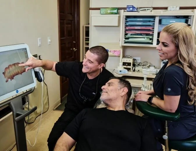 Dr. Gio and his assistant at Flossy Smiles reviewing a patient's dental x-rays with him